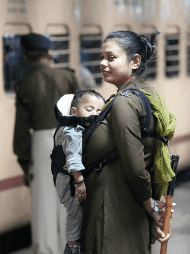 RPF personnel carrying her child performs her duty at Railway Station